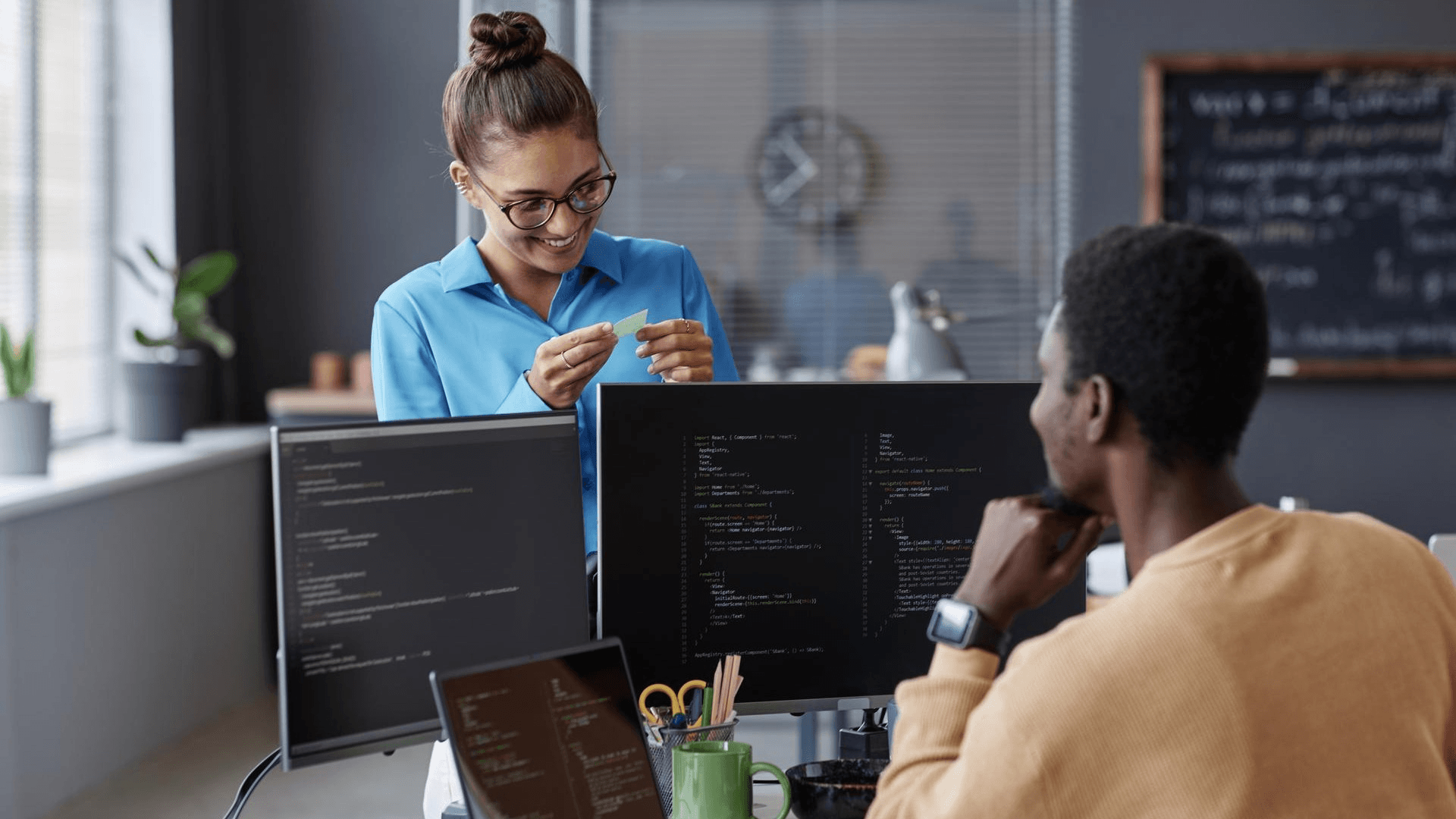 Two engineers collaborating at code monitors during an integration session